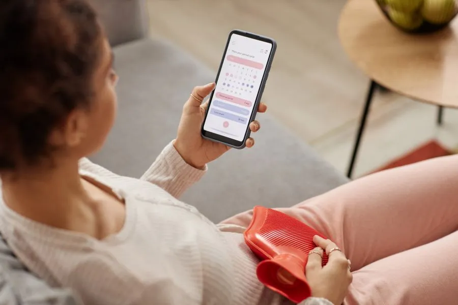 A woman on her phone tracking her cycle.